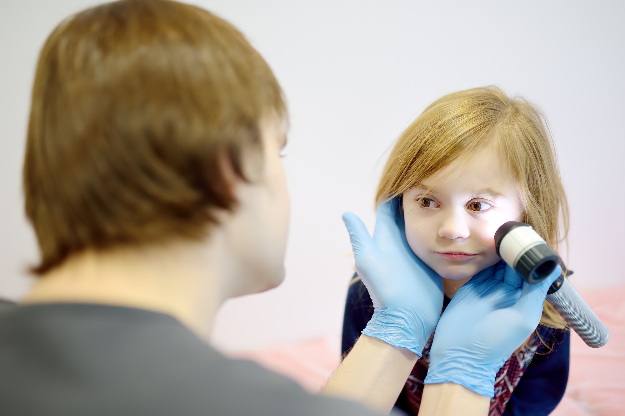 Cute little girl during appointment of dermatologist in modern clinic.