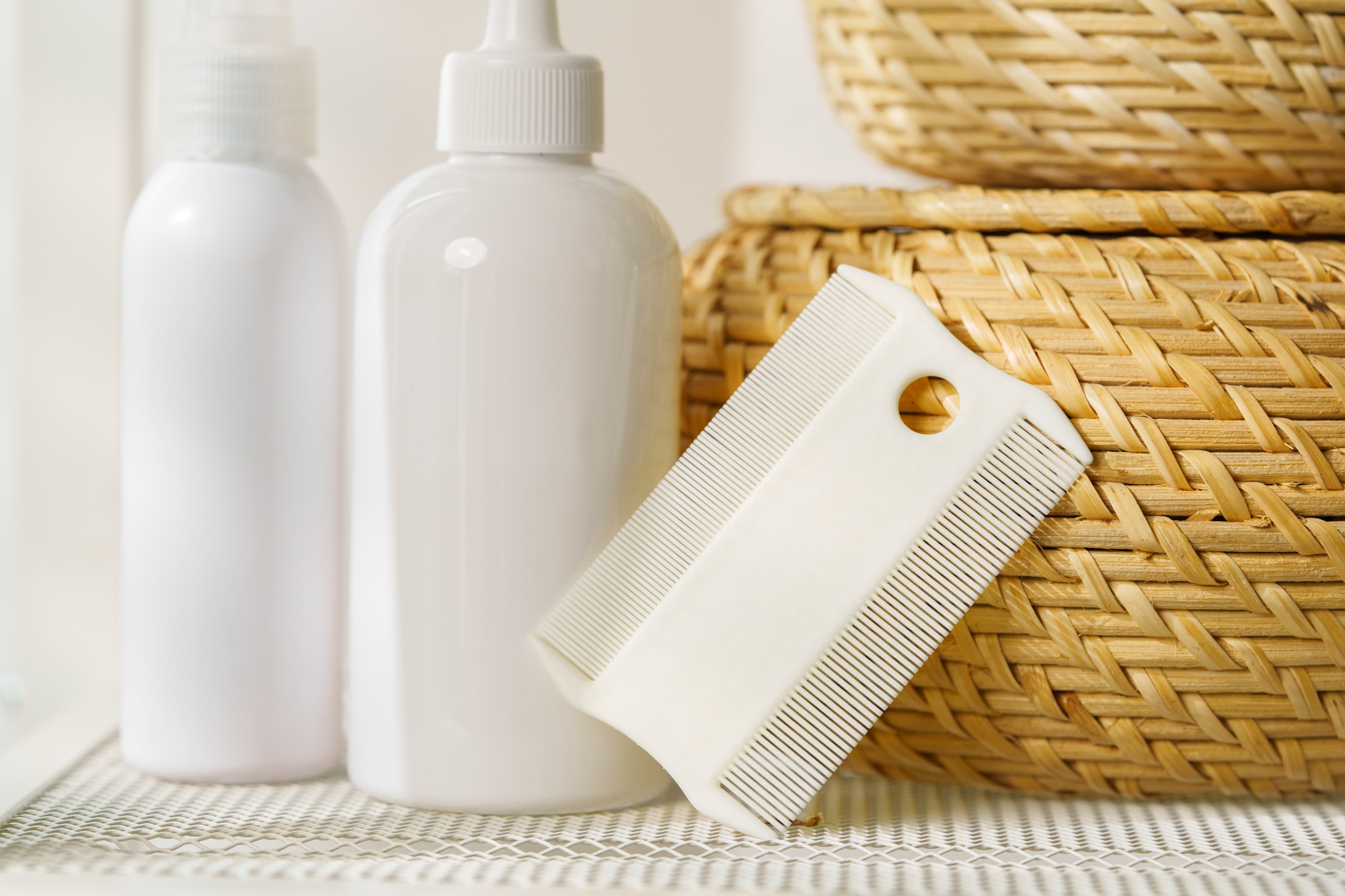 Bottles of Lice Treatment Products and a Comb on a Countertop