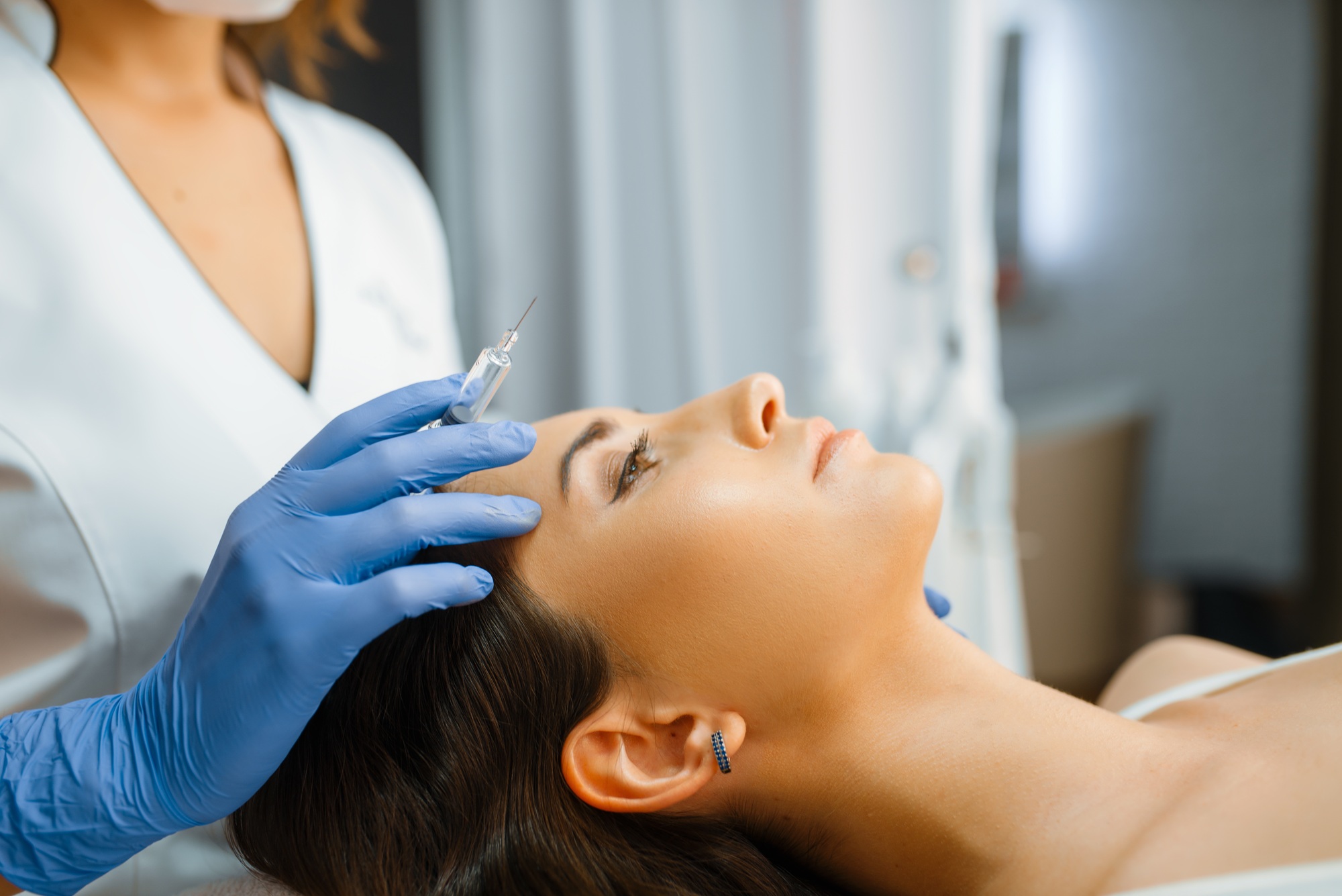 Cosmetician holds syringe with botox injection