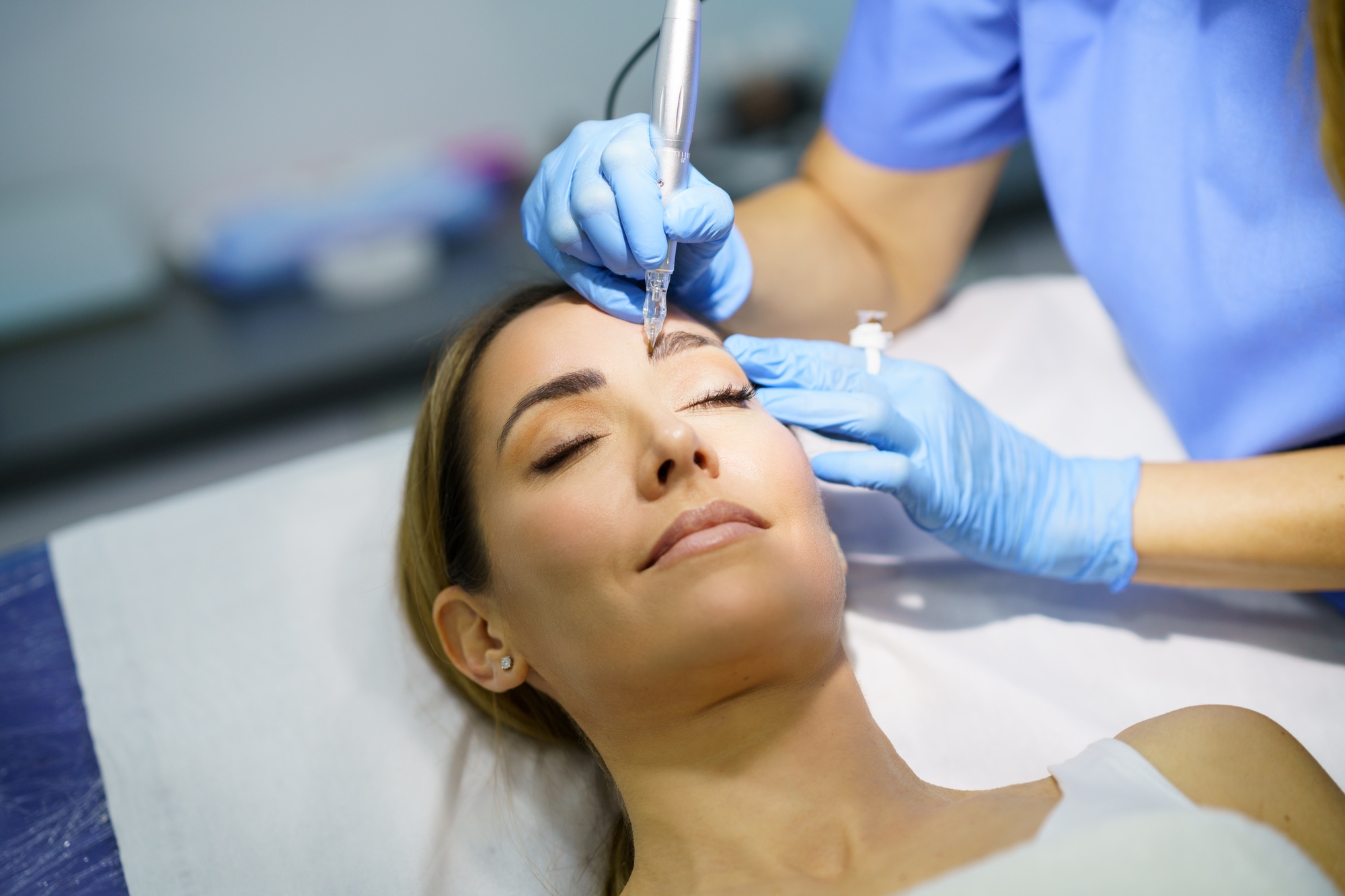 Permanent make-up for eyebrows of beautiful woman in a beauty salon. Micropigmentation treatment