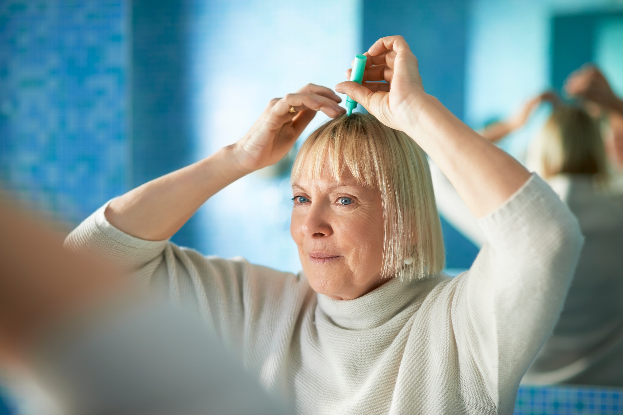 Senior Woman Checking Hairline For Hair Loss