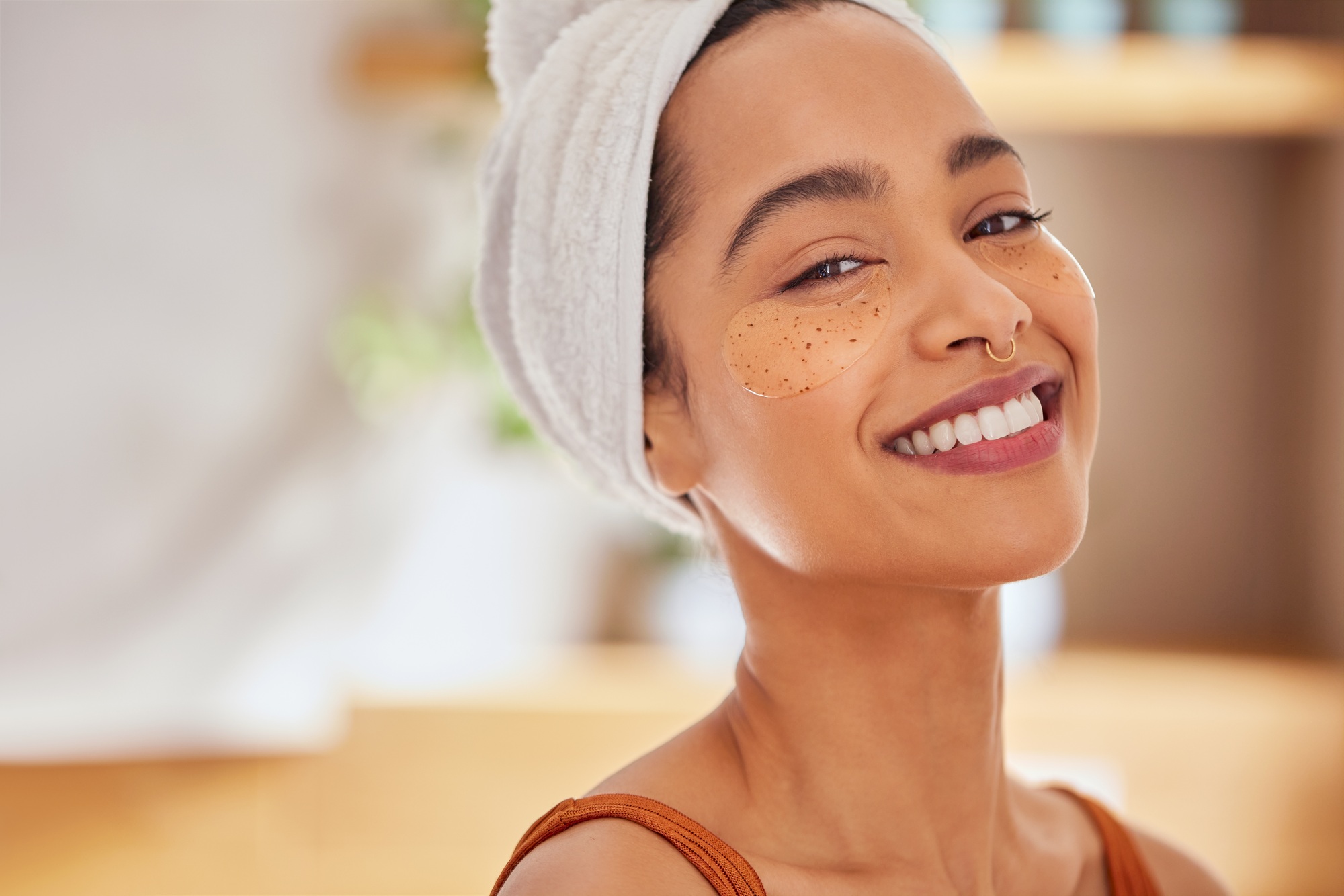 Young hispanic woman with eye mask patches smiling