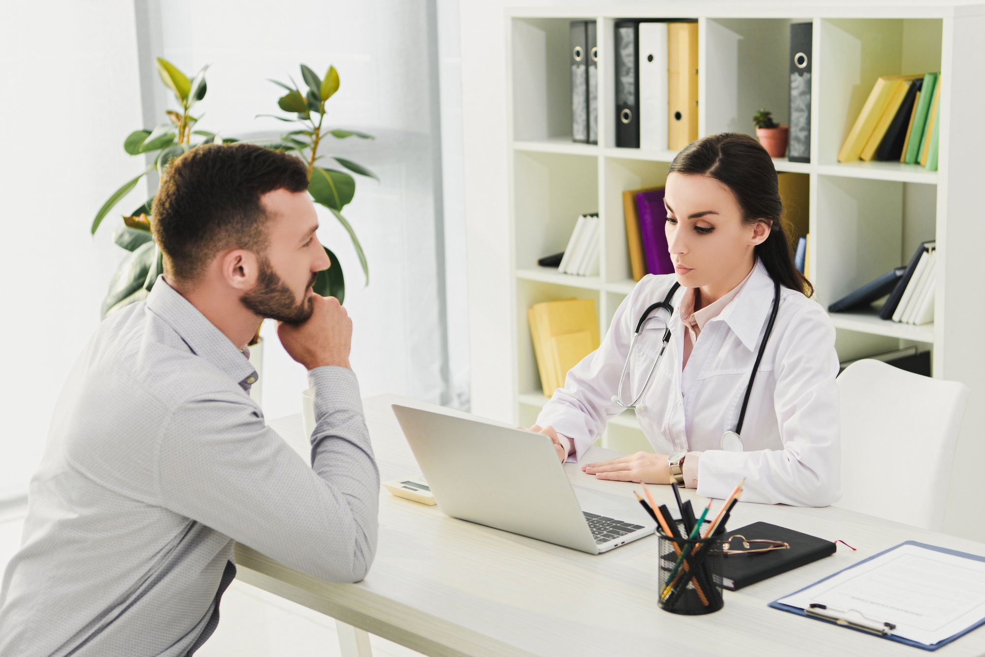 client and doctor in medical office with laptop