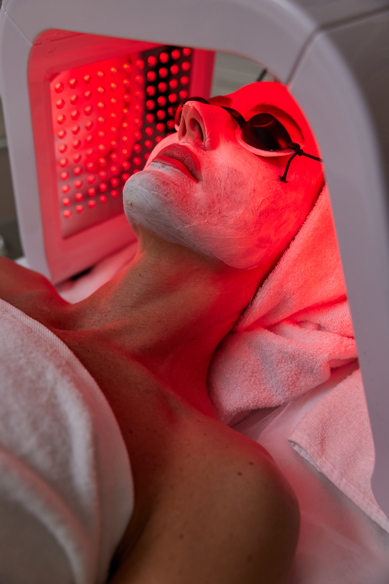 Woman getting facial treatment with led therapy.