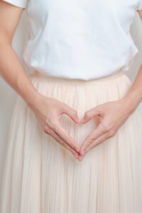 Woman hand heart shape over abdomen. Ovarian and Sexual Transmitted disease concept