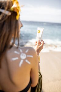 Woman with sunscreen lotion on the beach