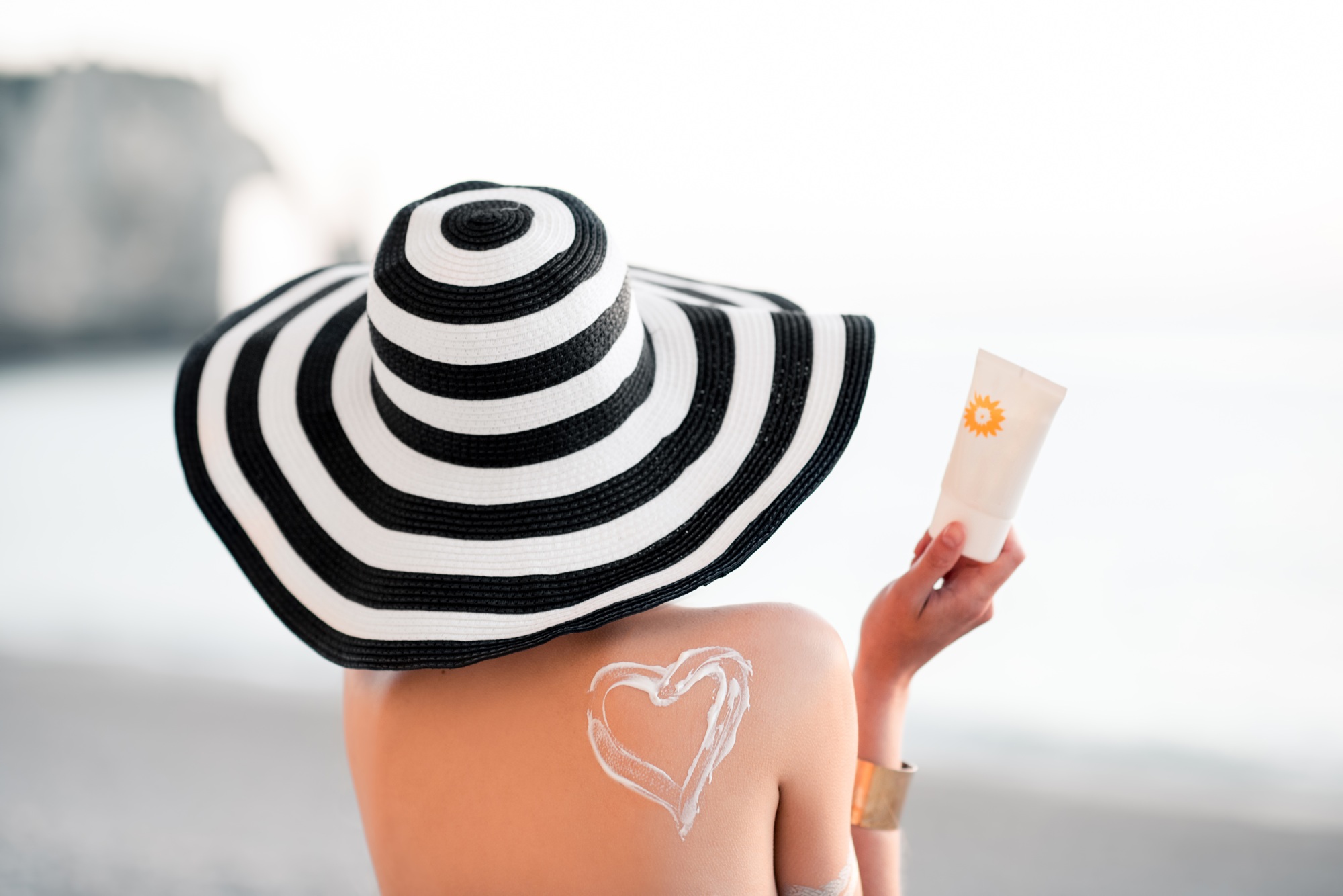 Woman sunbathing with sunscreen lotion