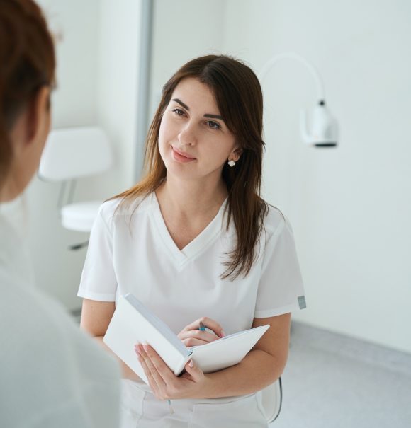 Gynecologist talking with female patient during consultation in hospital